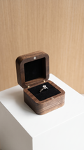 Walnut wood ring box with open lid, black velvet insert, ring on cushion