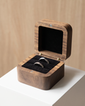 Open solid walnut ring box with black velvet lining and ring cushion