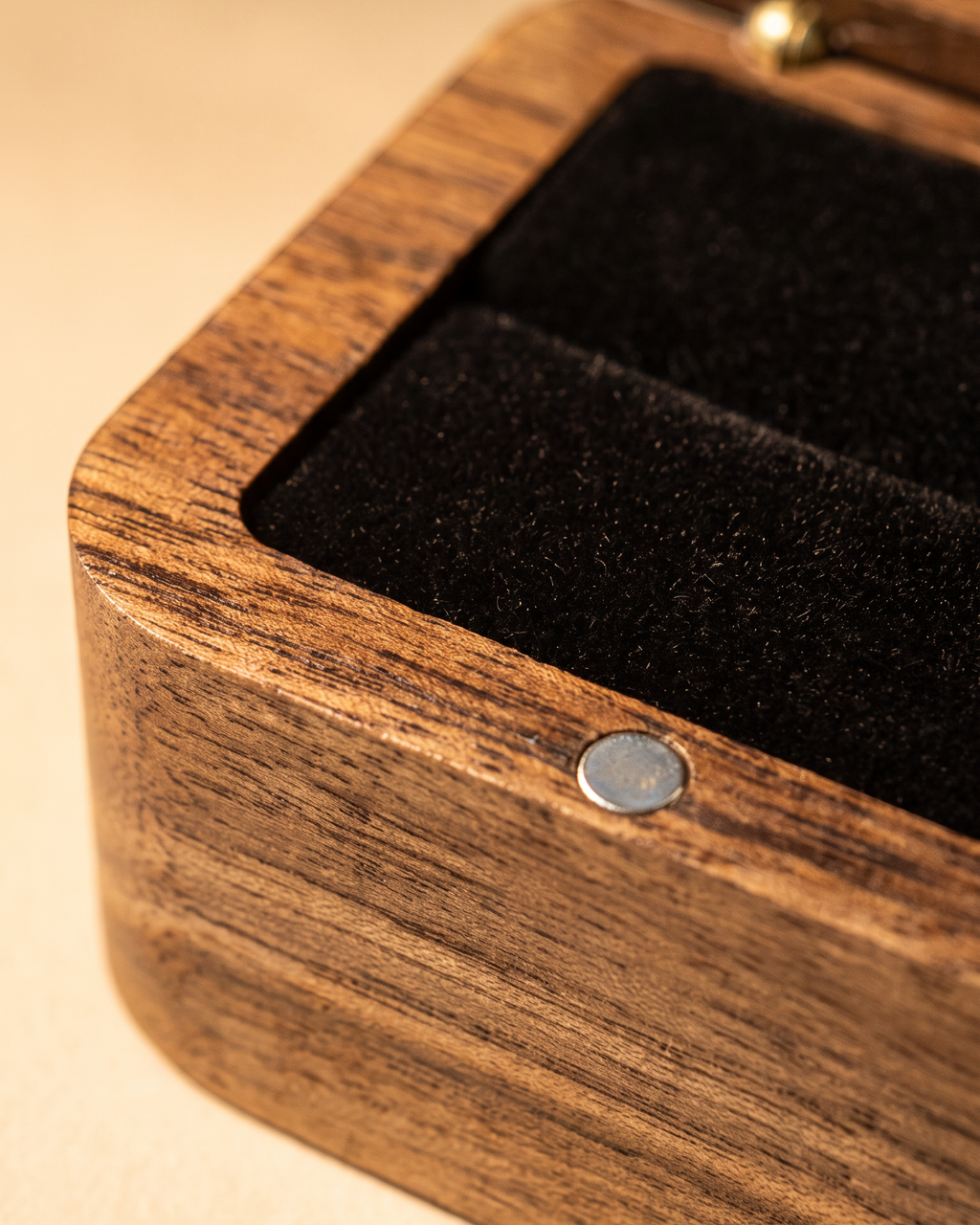 Solid walnut ring box close-up of metal button on the lid