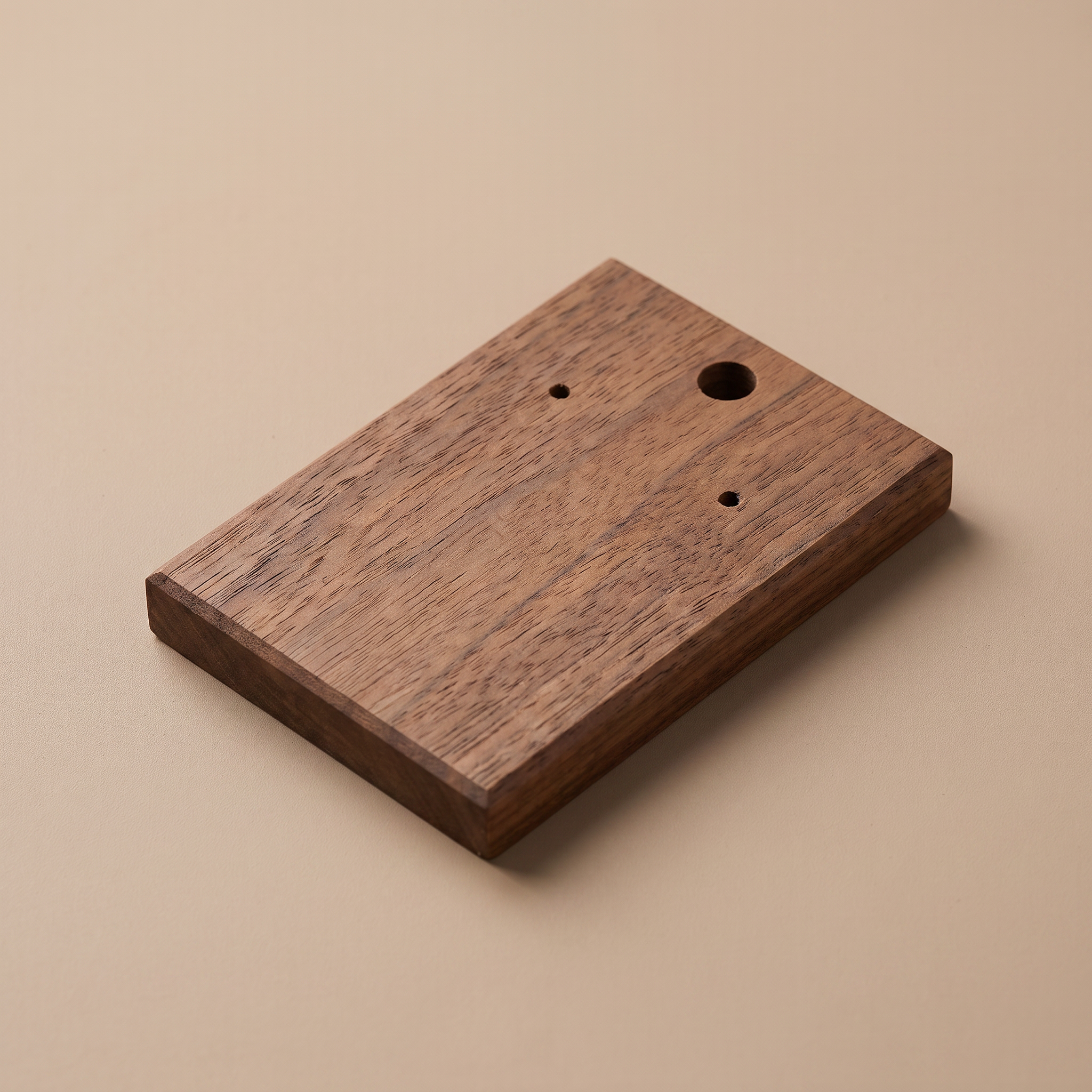 Walnut earring display board with three drilled openings, including one larger hole