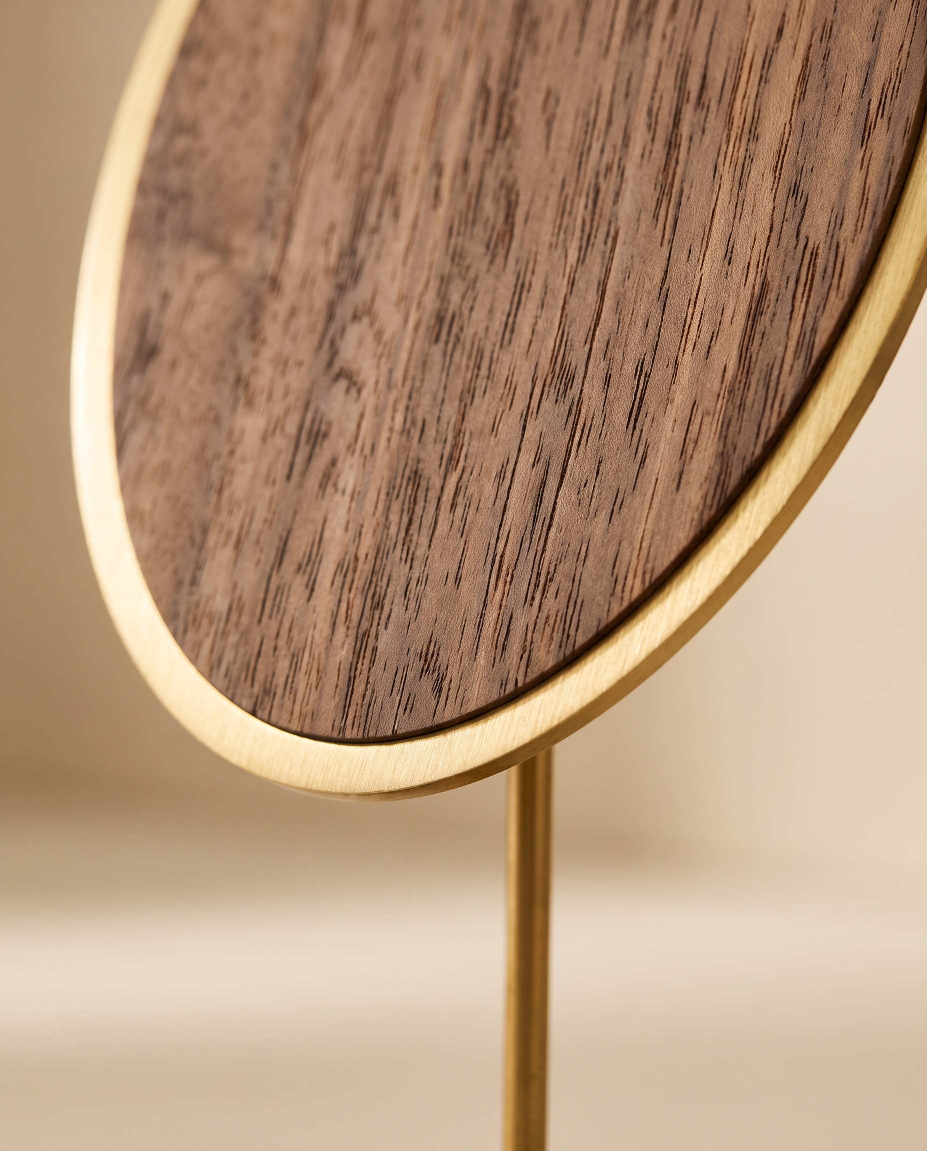 Close view of walnut oval necklace stand with brushed gold rim and post