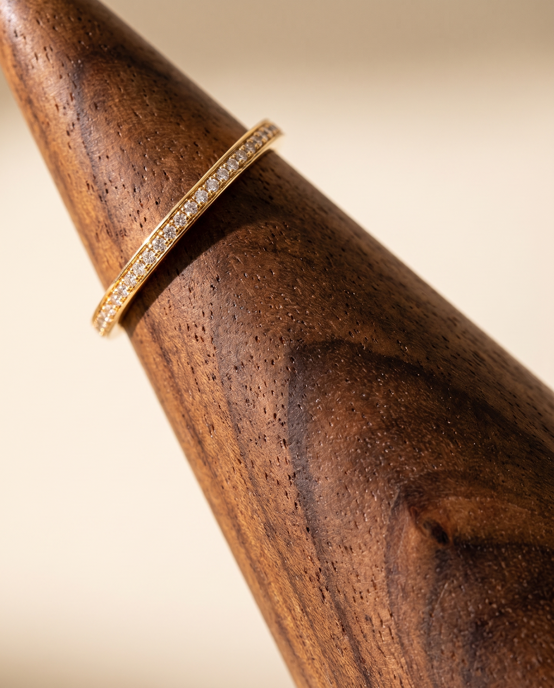 Close-up walnut ring cone holder with gold-tone band and sparkling stone detail