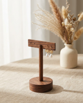 Walnut T-bar earring stand holding hoop and stud earrings on a circular base