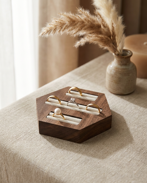 Walnut hexagon ring display stand with three velvet channels, holding several rings