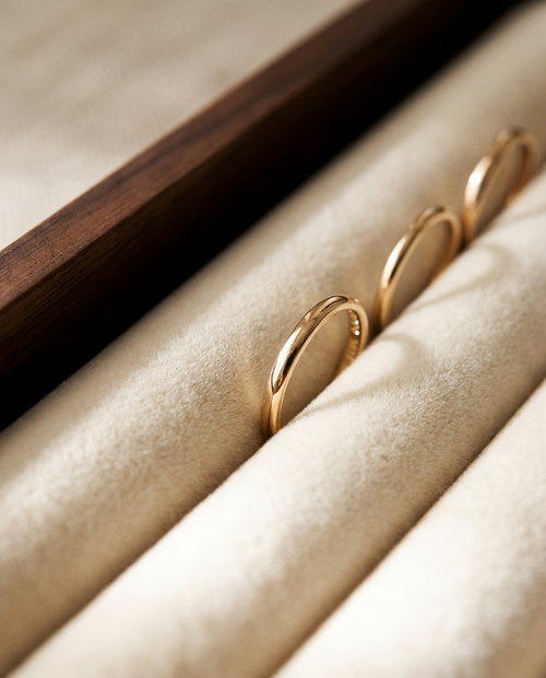 Gold-tone rings resting on beige fabric in a jewelry tray