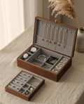 Walnut jewelry box with gray fabric lining, open with trays and necklace hooks visible.
