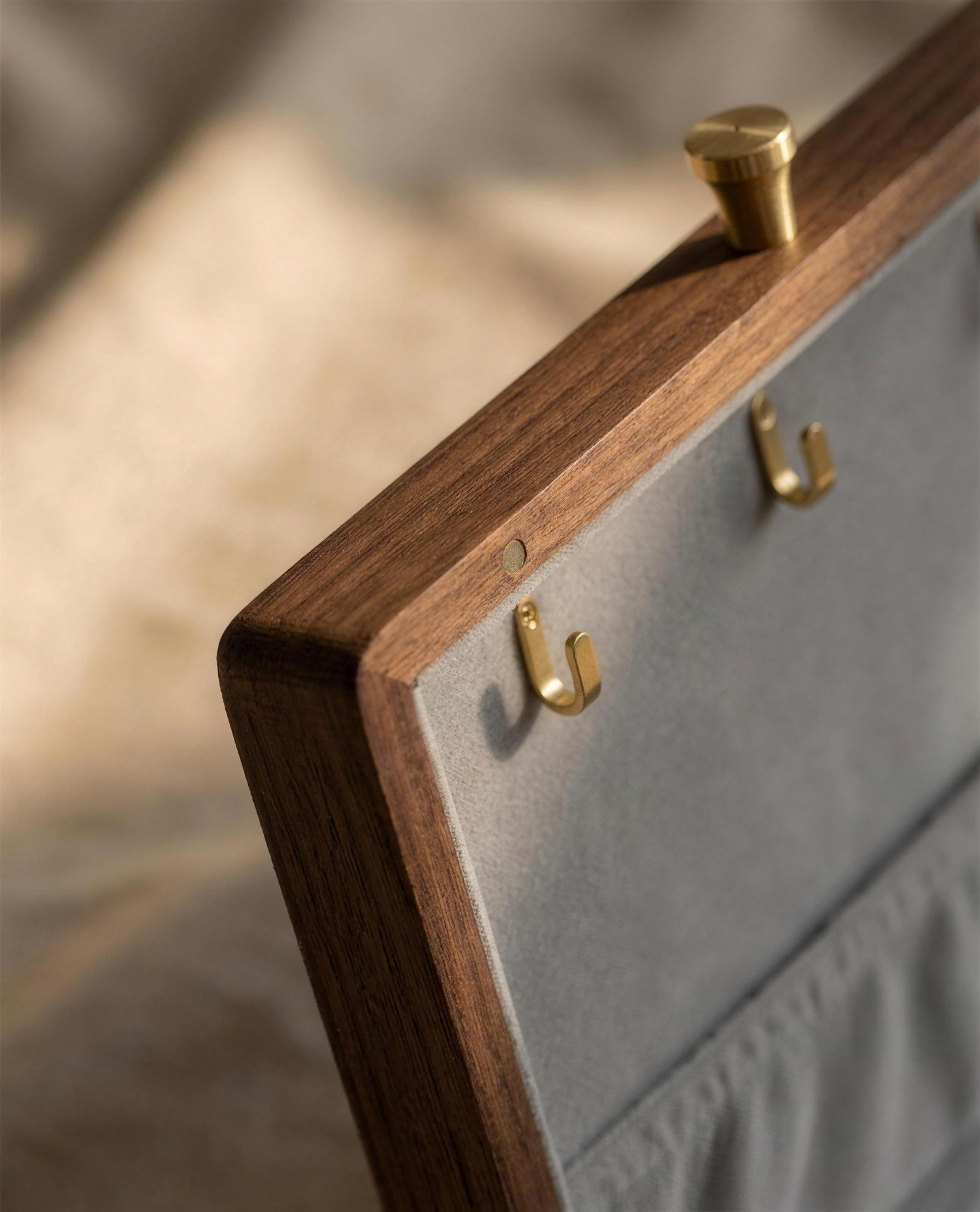 Walnut jewelry box corner with grey velvet panel and two brass hooks