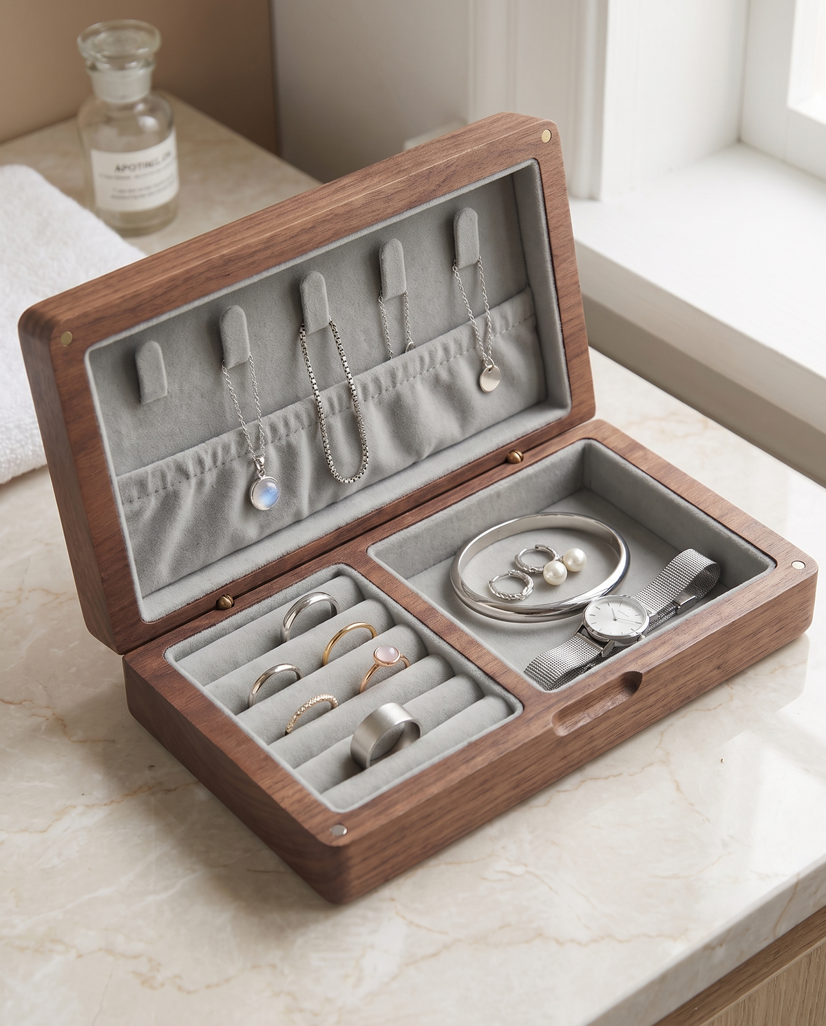 Walnut travel jewelry case open, gray velvet: silver chains on lid hooks, rings in the ring roll, bangle and watch in the compartment