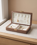 Walnut travel jewelry box with open lid and white velvet tray, showing necklace and ring sections