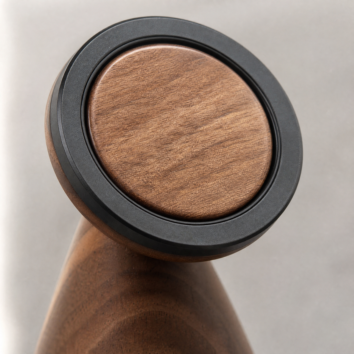 Walnut phone stand top with black rim over a circular magnetic plate
