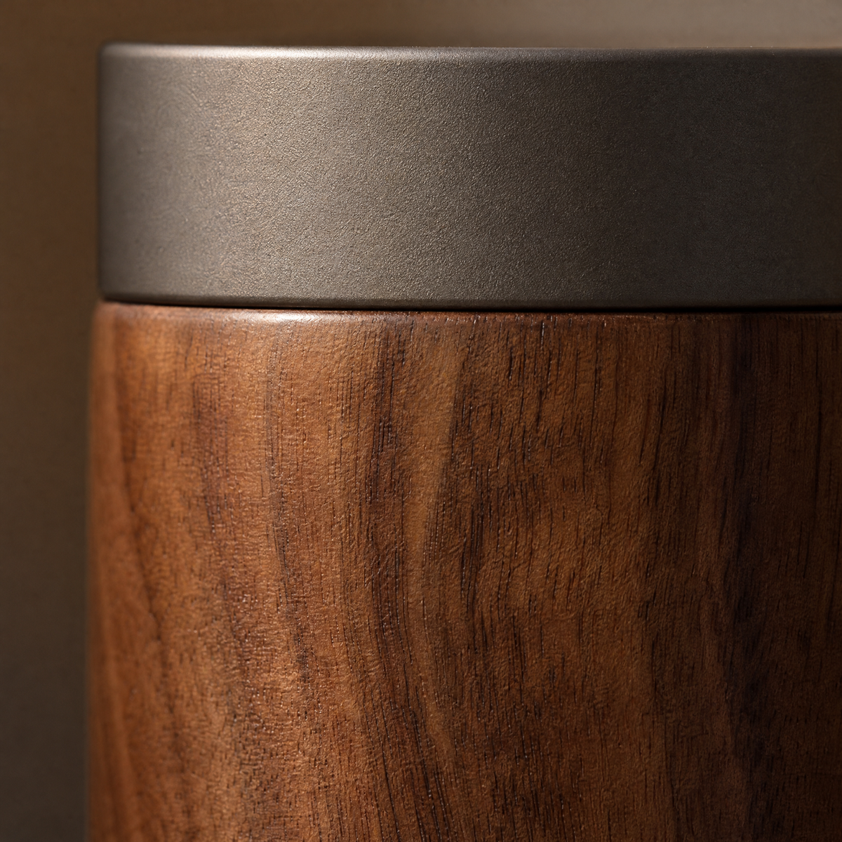 Close-up of the walnut grain and the brushed aluminium lid edge
