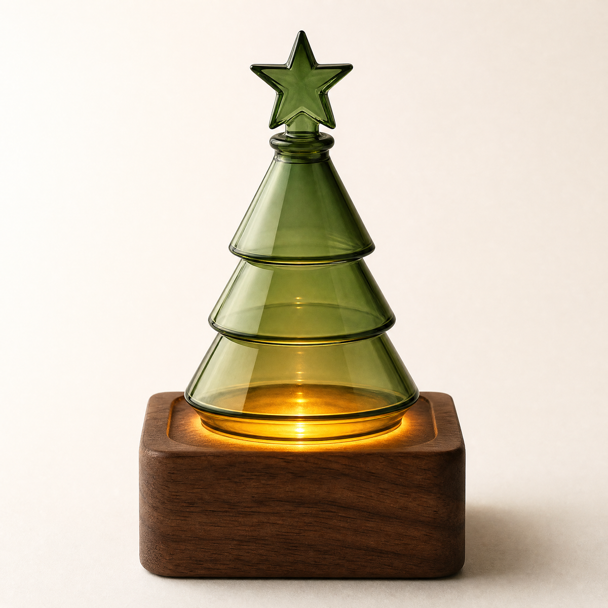 Green glass Christmas tree diffuser with star top and glowing lighted walnut base