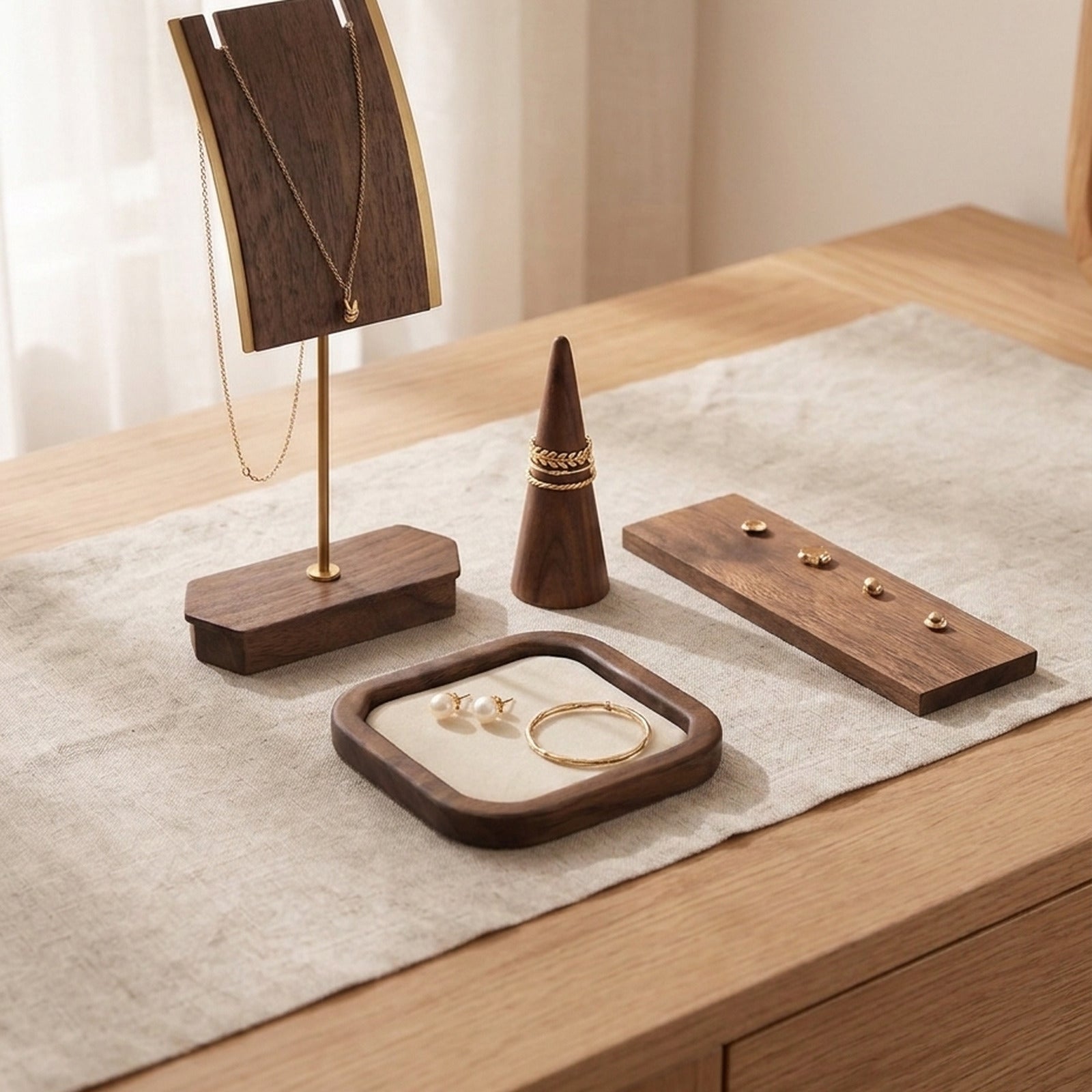 The Essential Set in solid black walnut: necklace stand, ring cone, earring board and velvet ring tray on a dresser