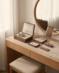 Wood jewelry organizer set on vanity: open box, necklace stand, tray and earring board